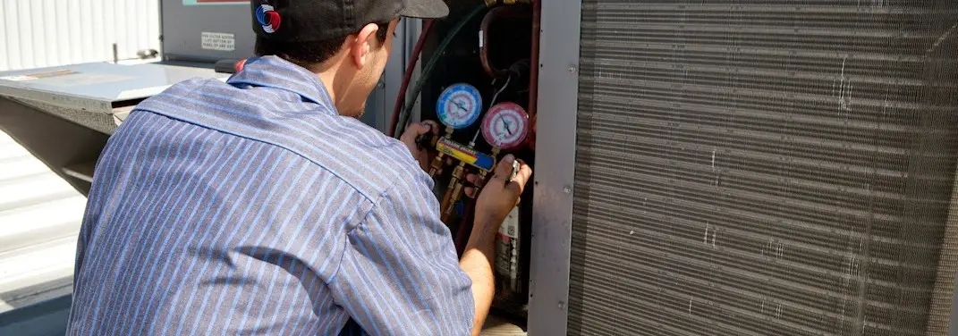 HVAC technician servicing a condenser unit in Middleton