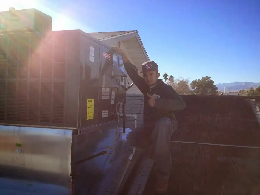 HVAC technician performing Boiler Repair on a rooftop unit in Middleton